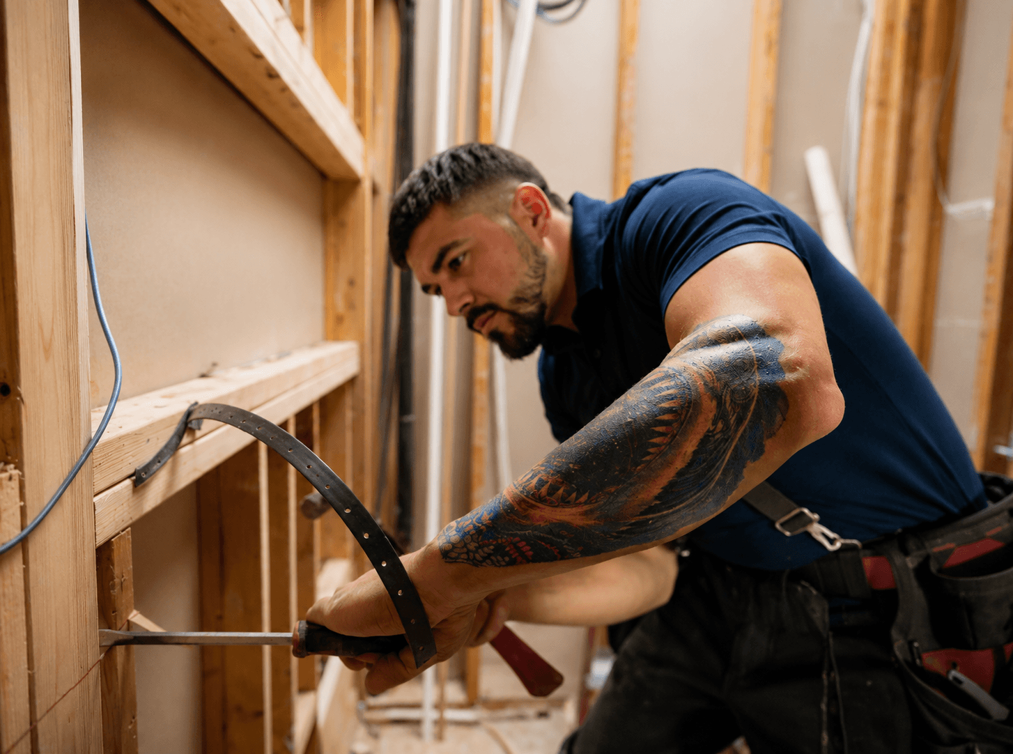 Grade A Plumbing plumber carrying out repair work inside a framed wall cavity